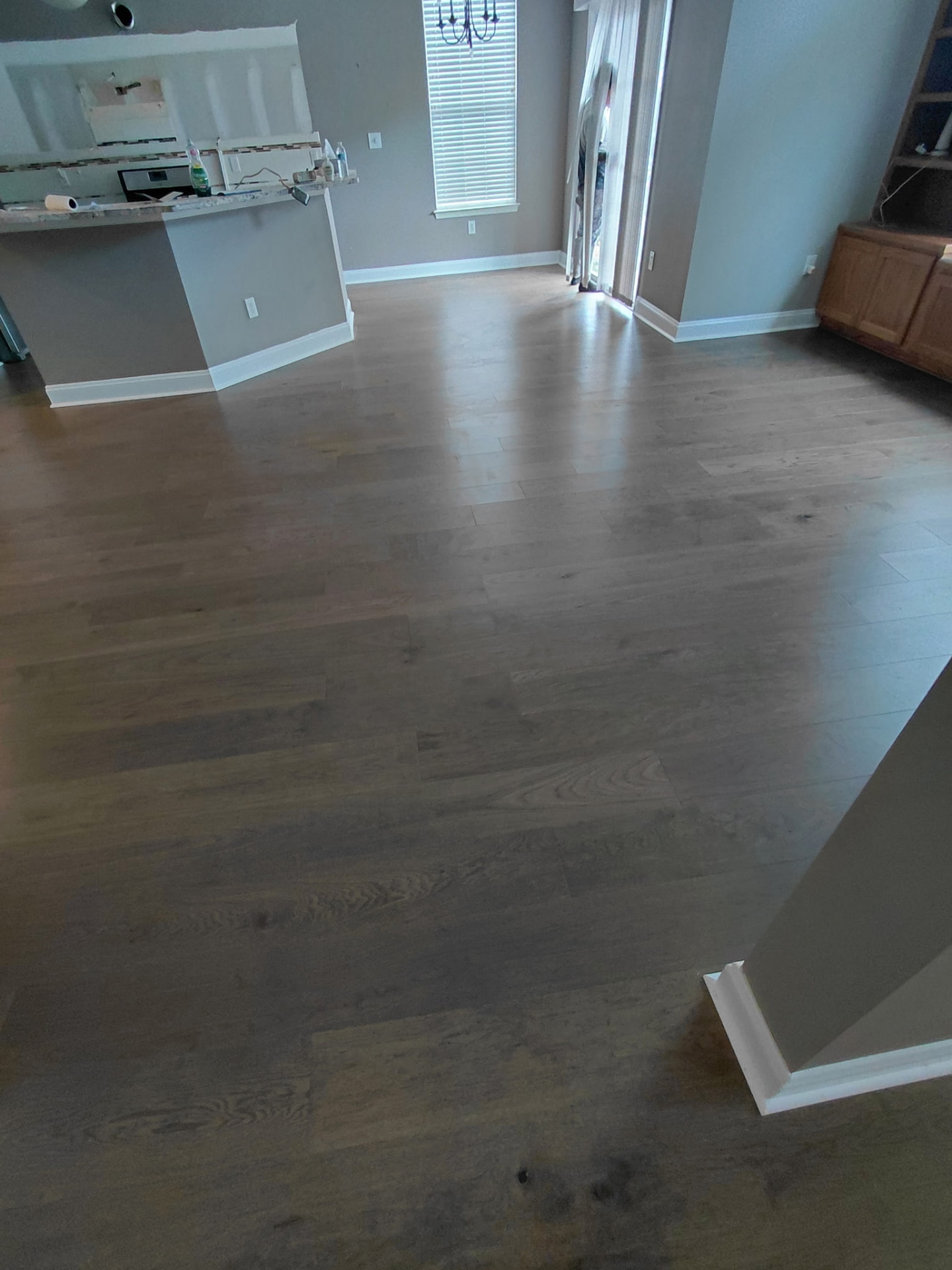 Finished dark hardwood flooring in a remodeled living space